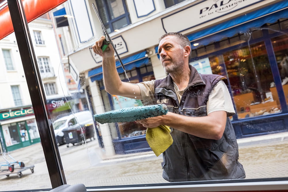 Eclanet-accueil Technicien lavant des vitres pour Eclanet, une entreprise du Groupe CANDOR